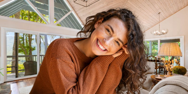 A girl in brown sweater smiling